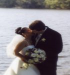 bride and groom kissing by the lake